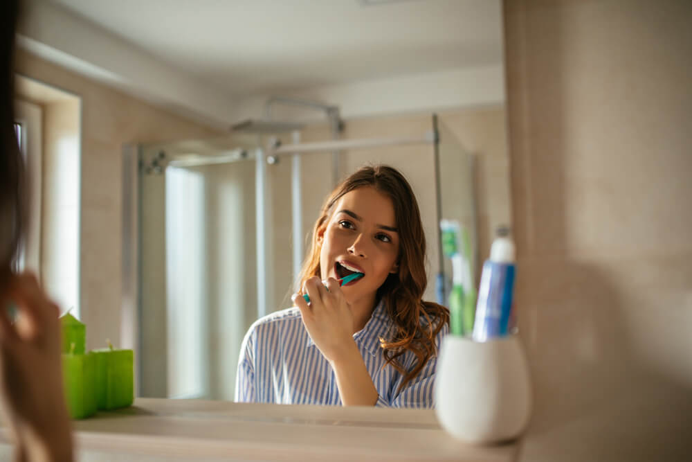 浴室で歯を磨く女性