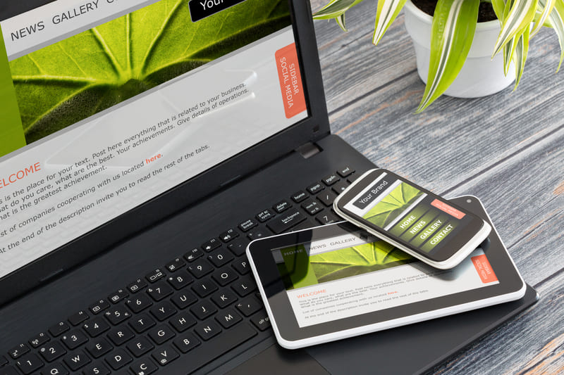 ノートパソコンの上にタブレットとスマホ