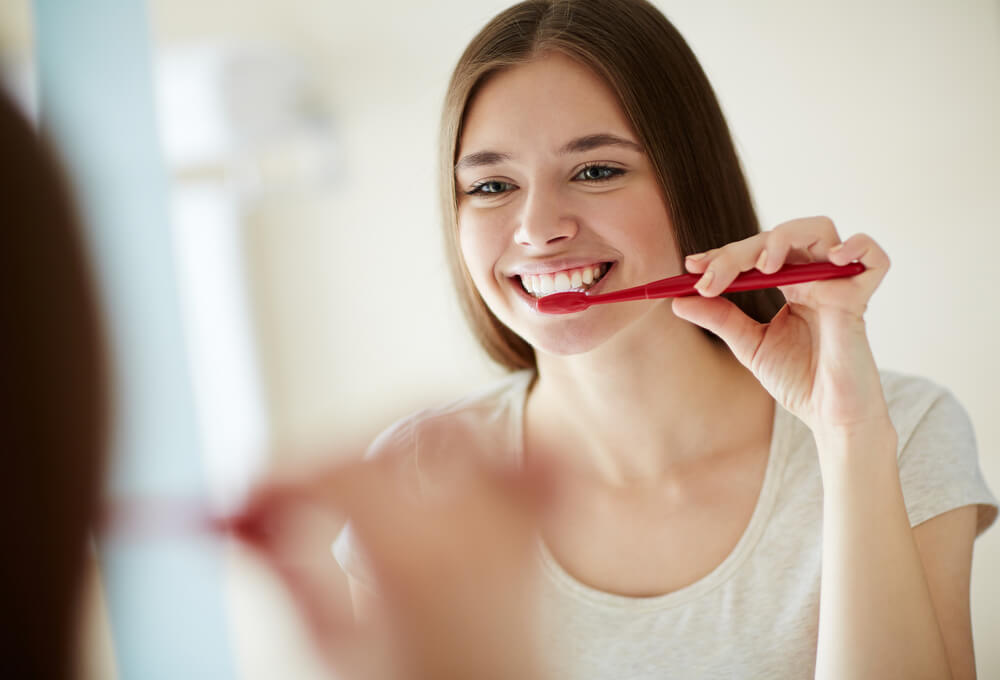 鏡の前で歯磨きをする女性